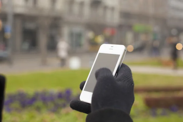 Smartphone à la main avec gants — Photo