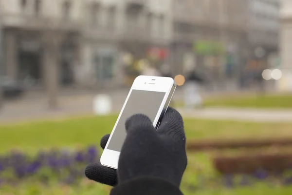 Smartphone à la main avec gants — Photo