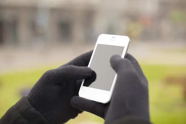 Smartphone in hand with gloves — Stock Photo, Image