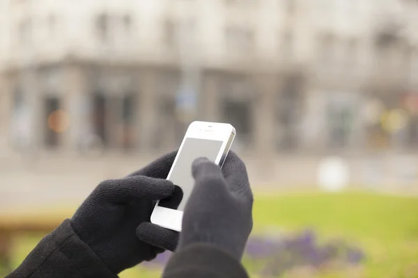 Smartphone na mão com luvas — Fotografia de Stock