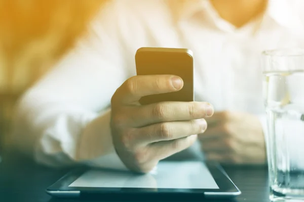 Man with smartphone and tablet computer in restaurant — Stock Photo, Image