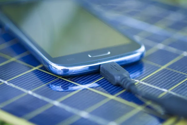 Зарядка мобільного телефону за допомогою сонячного зарядного пристрою — стокове фото
