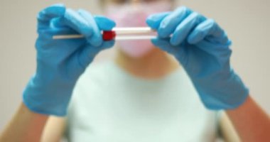 Coronavirus COVID-19 test kiti tutan doktor hemşire, OP NP hasta numunesi almak için tüp, PCR DNA RNA protokol dosyası 4K video. Koruyucu ekipmana, eldivenlere, maskeye ve gözlüğe sahip bilim adamı DNA RNA virüsü testini kontrol ediyor.