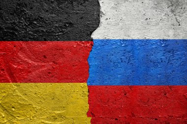 Almanya, Rusya 'ya karşı. Solunda Alman bayrağı, sağında Rus bayrağı olan çatlamış beton bir duvar.