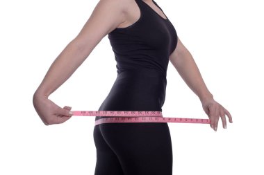 Şişman bir kadın, beyaz bir stüdyonun arka planındaki kemer ölçüsünü ölçer. Diyetin sonucundan memnun ve birkaç kilo daha vermiş. Boşluğu kopyala