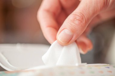 El seçilmiş bir ıslak mendil paketi kutusunda, ıslak mendil bir kadının elinde