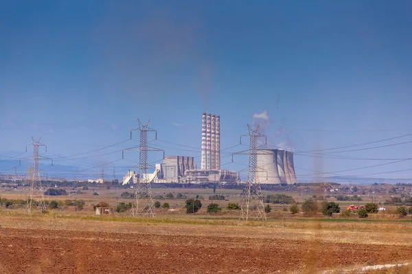 A thermoelectric coal power plant Amyntaio in Greece, with big chimneys in a rural landscape uses lignite coal as fuel