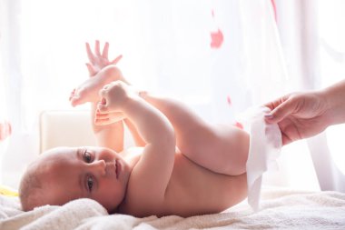 The mother takes care of the baby's skin and wipes the baby's bottom with water and wet wipes