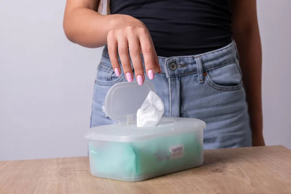 タンクトップの女性は使い捨てパッケージから手をきれいにするために1つのぬれたワイプを取ります 衛生手順と感染症の予防 — ストック写真