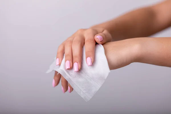 Cleaning hands with wet wipes, light pink nails, prevention of infectious diseases, corona19 protection stock photo