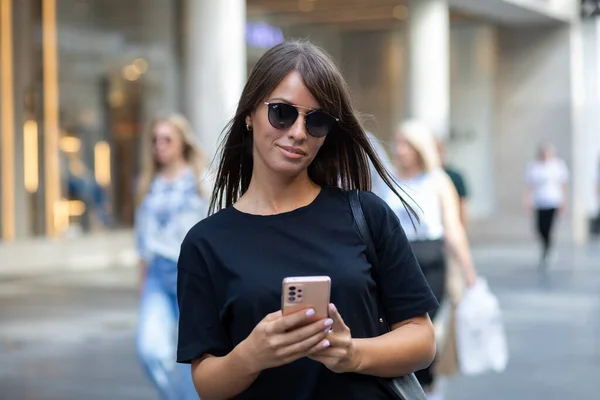 Vacker Leende Kvinna Svart Skjorta Och Solglasögon Sms Smartphone Gatan — Stockfoto