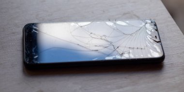 Masa masaüstü stok fotoğrafında kırık dokunmatik ekranlı akıllı telefon