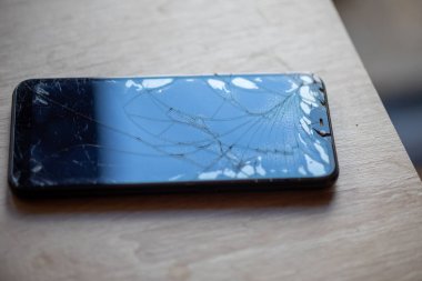 Masa masaüstü stok fotoğrafında kırık dokunmatik ekranlı akıllı telefon
