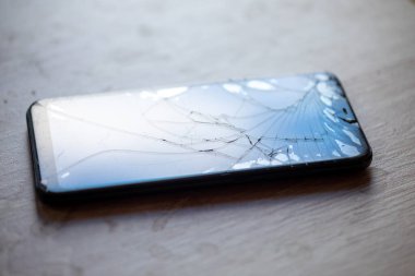 Masa masaüstü stok fotoğrafında kırık dokunmatik ekranlı akıllı telefon