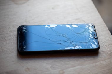 Masa masaüstü stok fotoğrafında kırık dokunmatik ekranlı akıllı telefon