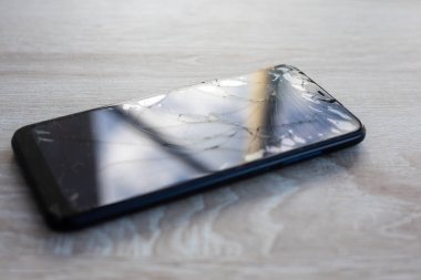 Masa masaüstü stok fotoğrafında kırık dokunmatik ekranlı akıllı telefon