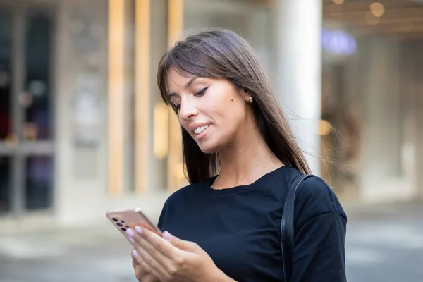 Vacker Leende Kvinna Svart Skjorta Sms Smartphone Gatan Centrum — Stockfoto