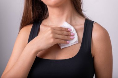 Islak mendilli, pamuklu bluzlu, temiz boyunlu genç bir kadın.