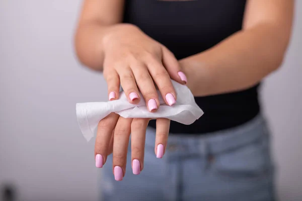 Young woman in black tank top cleaning hands with wet wipes, prevention of infectious diseases, corona19 protection stock photo