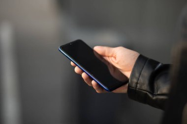 Cep telefonunu elinde tutan tanınmayan bir adam, internet uygulaması üzerinden sohbet ediyor.