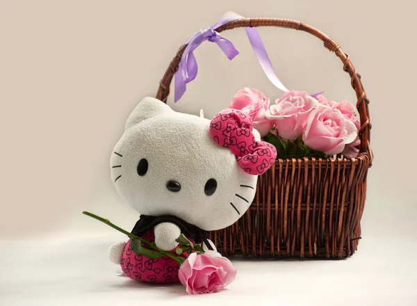 sepet ve beyaz bir kedi oyuncak pembe güller