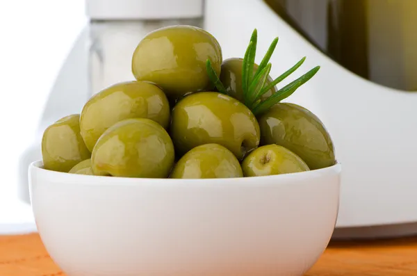 Green olives in a white ceramic bowl — Stock Photo, Image