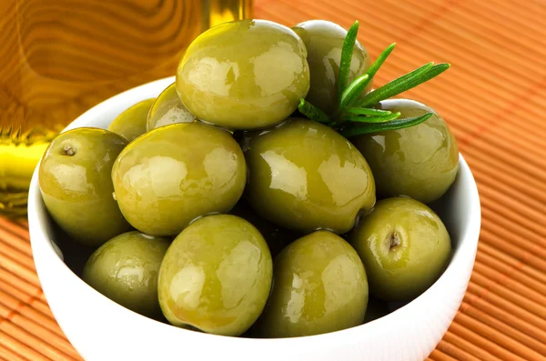 Green olives in a white ceramic bowl — Stock Photo, Image