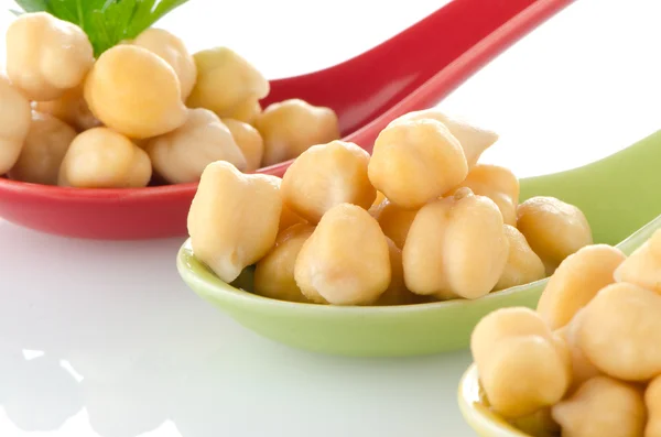 Chickpeas over spoons — Stock Photo, Image