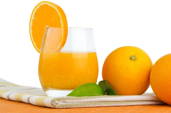 Kuppi appelsiinimehua ja tuoretta appelsiinia — kuvapankkivalokuva