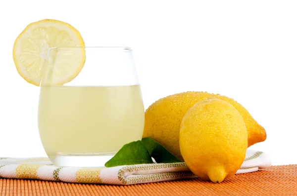 Cup of lemon juice and fresh lemons — Stock Photo, Image