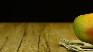 elma mango ve ahşap masa üstü siyah arka plan üzerinde kayar suyu