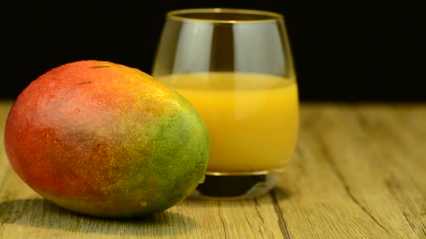 Mango de manzana y jugo deslizándose sobre mesa de madera sobre fondo negro — Vídeos de Stock