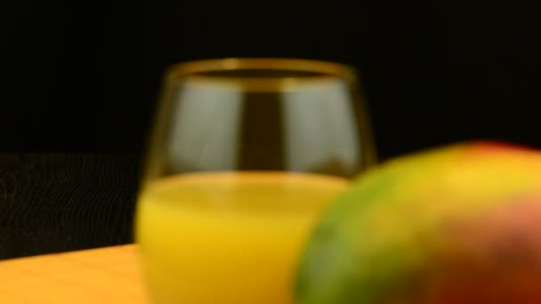 Mango de manzana y jugo deslizándose sobre mesa de madera sobre fondo negro — Vídeos de Stock