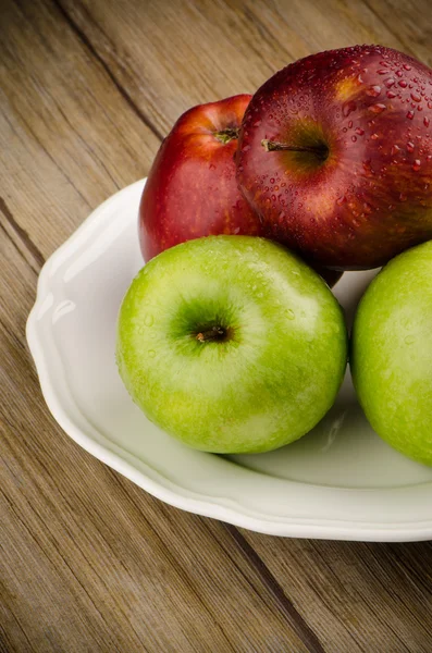 Äpfel in einem weißen Keramikteller — Stockfoto