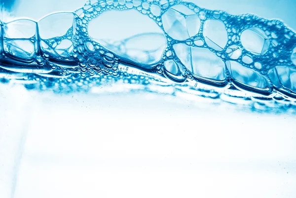 Luchtbellen in blauw water — Stockfoto