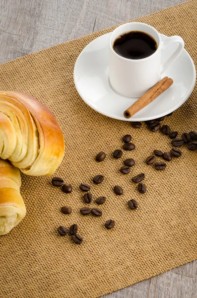 Kopje zwarte koffie en een croissant — Stockfoto