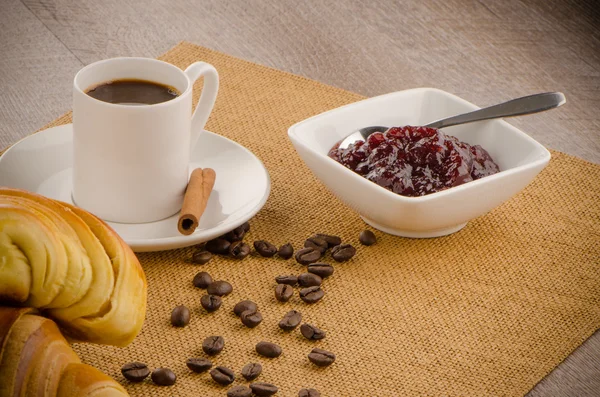 Kopje zwarte koffie en een croissant — Stockfoto