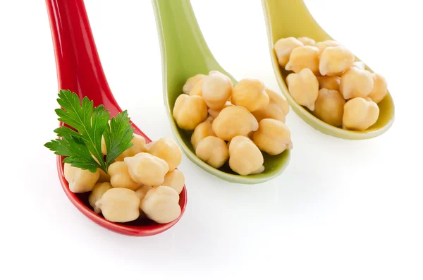 Chickpeas over spoons — Stock Photo, Image