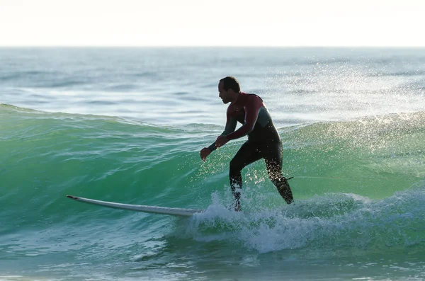 Larga tabla surfeando las olas al atardecer —  Fotos de Stock