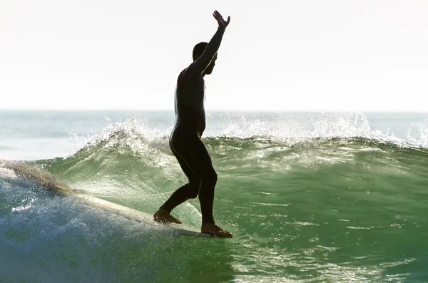 Long boarder surfing the waves at sunset — Stock Photo, Image