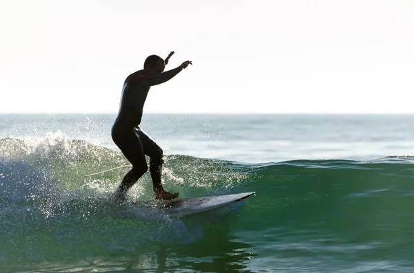 Long pensionnaire surfant sur les vagues au coucher du soleil — Photo