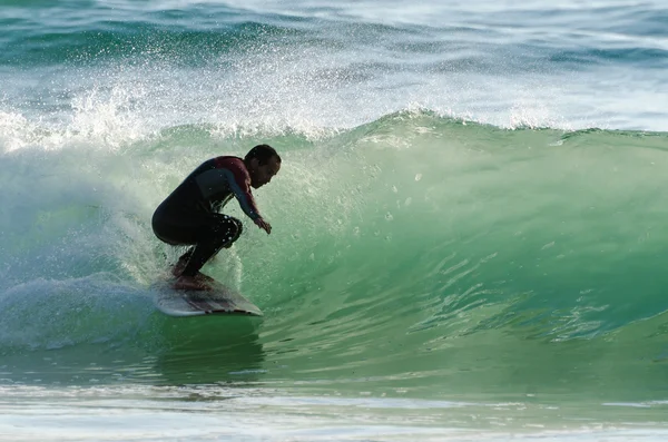 Lange boarder surfen op de golven bij zonsondergang — Stockfoto