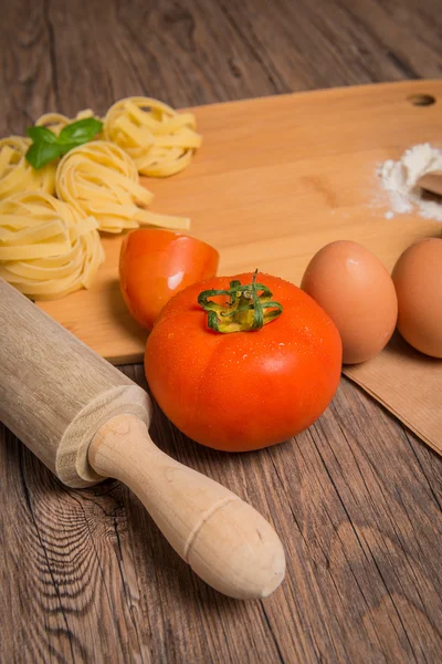 Raw pasta, tomato and eggs — Stock Photo, Image