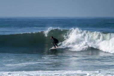 Okyanus dalgaları üzerinde eylem güneşli bir sörfçü.