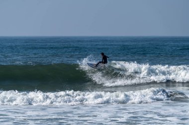 Okyanus dalgaları üzerinde eylem güneşli bir sörfçü.