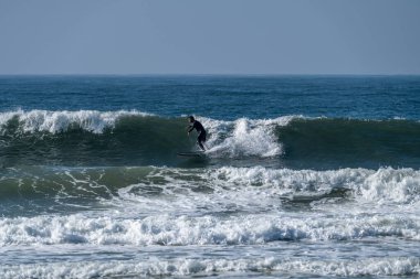 Okyanus dalgaları üzerinde eylem güneşli bir sörfçü.