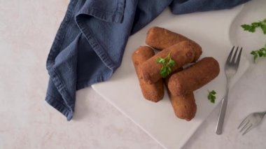 Et kroketleri ve maydanoz yaprakları mutfak tezgahındaki beyaz seramik tabaklarda..