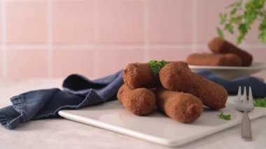 Et kroketleri ve maydanoz yaprakları mutfak tezgahındaki beyaz seramik tabaklarda..