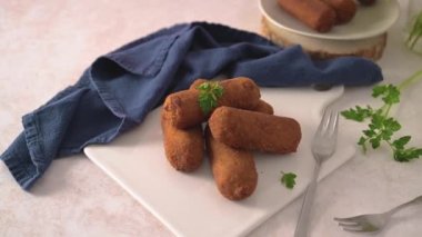 Et kroketleri ve maydanoz yaprakları mutfak tezgahındaki beyaz seramik tabaklarda..
