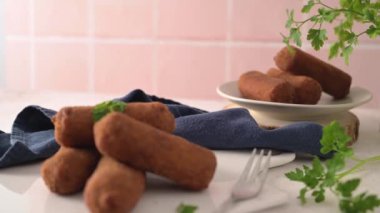 Et kroketleri ve maydanoz yaprakları mutfak tezgahındaki beyaz seramik tabaklarda..